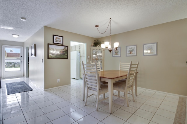 dining room featuring an inviting chandelier, light tile patterned floors, and a textured ceiling