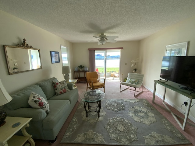 living room featuring ceiling fan, a textured ceiling, and carpet flooring