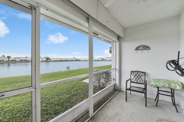 sunroom featuring a water view