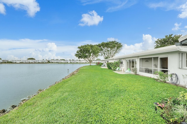 view of yard featuring a water view and a sunroom