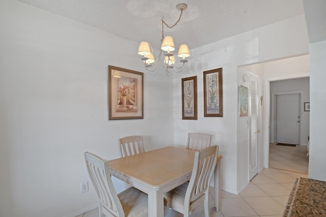 dining area featuring light tile patterned floors, a chandelier, and a textured ceiling