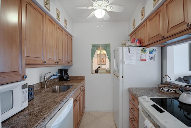 kitchen featuring stone counters, sink, light tile patterned floors, ceiling fan, and white appliances