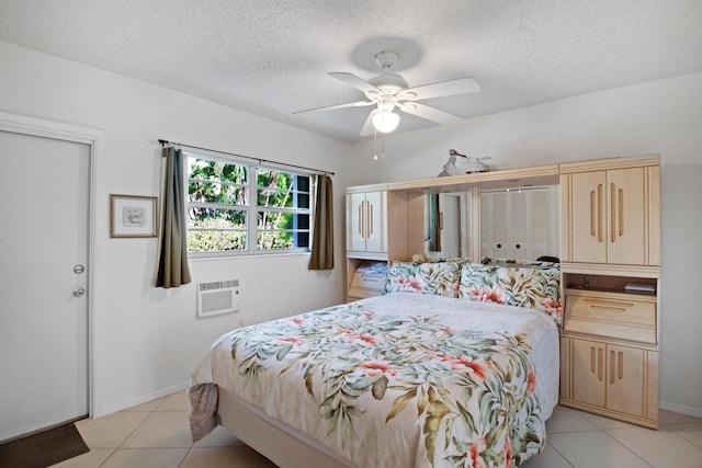 bedroom with ceiling fan, a wall mounted air conditioner, a textured ceiling, and light tile patterned flooring