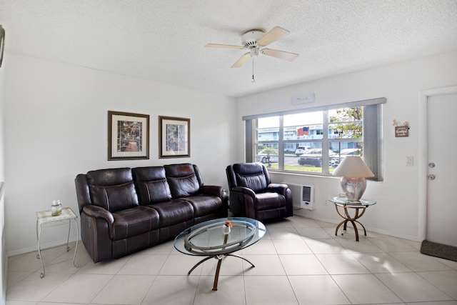 living room with ceiling fan, heating unit, light tile patterned floors, and a textured ceiling