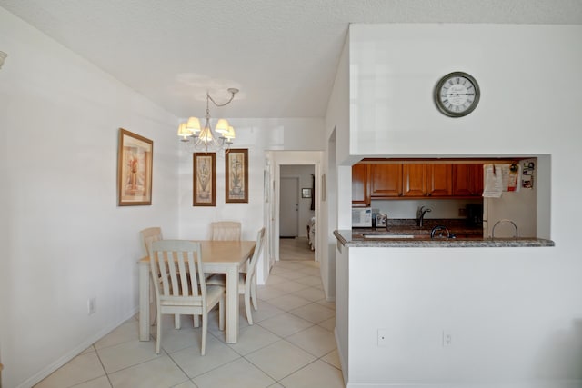 kitchen featuring hanging light fixtures, light tile patterned floors, a notable chandelier, and kitchen peninsula