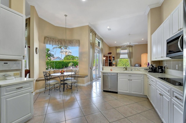 kitchen featuring appliances with stainless steel finishes, decorative light fixtures, white cabinetry, sink, and crown molding