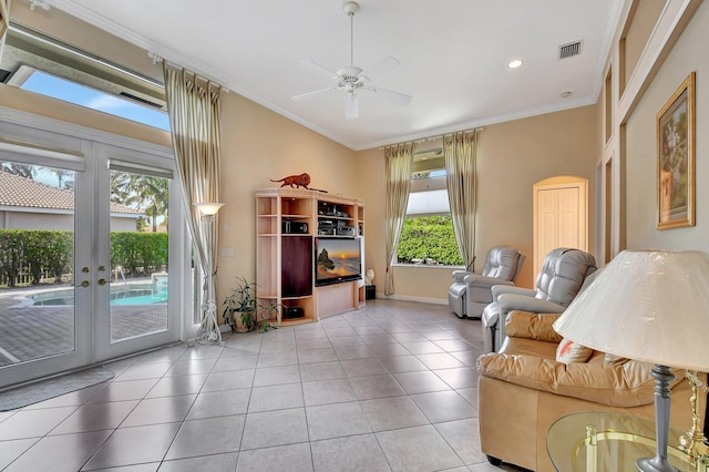 tiled living room featuring crown molding, ceiling fan, and french doors