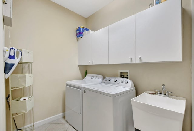 clothes washing area featuring sink, washing machine and dryer, cabinets, and light tile patterned flooring