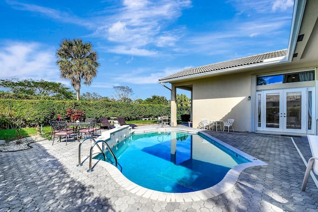 view of pool with french doors and a patio area