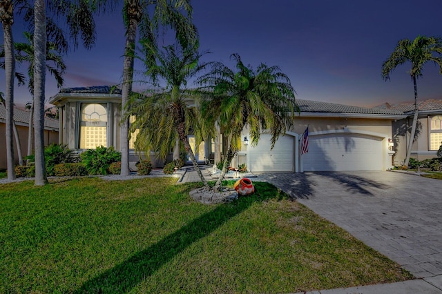 view of front of house featuring a garage and a lawn