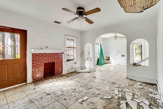 1839 NW 49th St, Miami, FL 33142 - unfurnished living room with a brick fireplace, a healthy amount of sunlight, and ceiling fan
