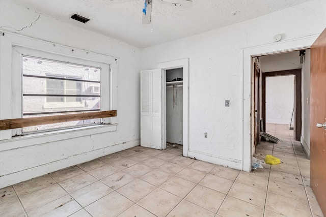 1839 NW 49th St, Miami, FL 33142 - unfurnished bedroom with ceiling fan, a textured ceiling, and a closet