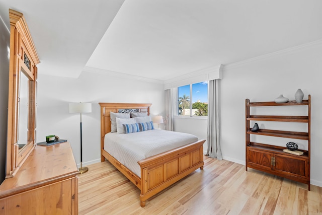 bedroom featuring crown molding and light hardwood / wood-style floors