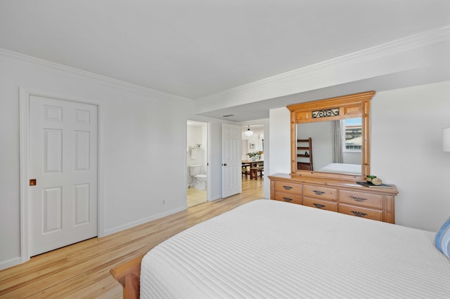 bedroom featuring crown molding, ensuite bathroom, and light wood-type flooring