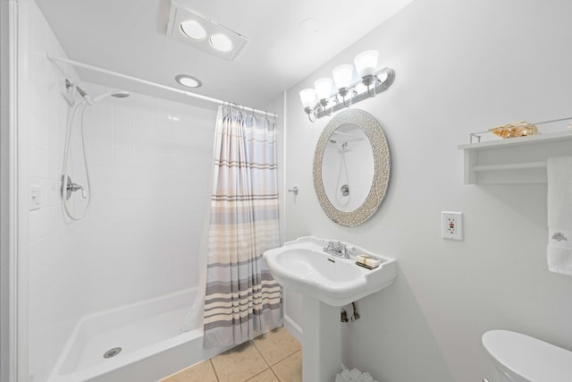 bathroom featuring curtained shower, tile patterned floors, and toilet