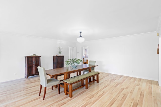 dining room with crown molding and light hardwood / wood-style floors