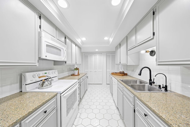 kitchen with a tray ceiling, white appliances, and white cabinetry