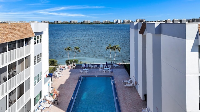 view of swimming pool featuring a water view and a patio