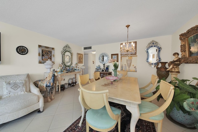 dining room featuring light tile patterned floors, a notable chandelier, and a textured ceiling