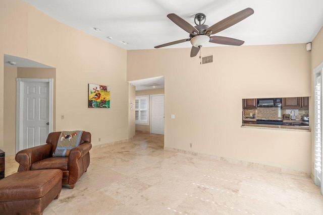 living room featuring ceiling fan and lofted ceiling