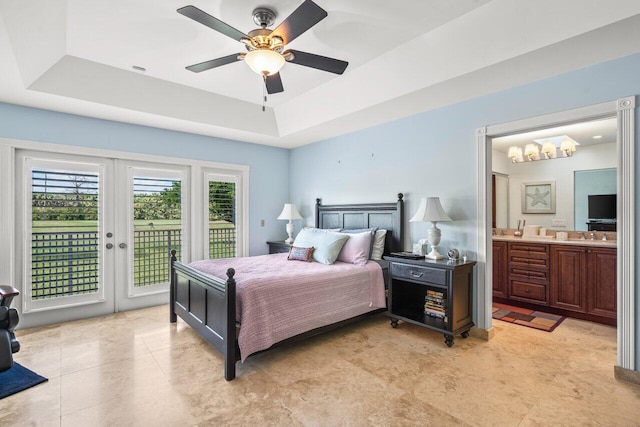 bedroom with ceiling fan, ensuite bathroom, access to exterior, and a raised ceiling