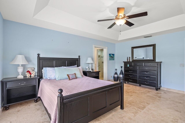 bedroom with ceiling fan and a tray ceiling