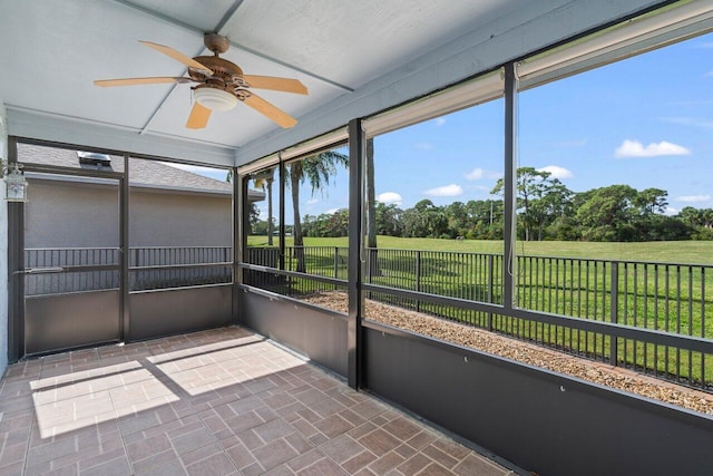 unfurnished sunroom featuring ceiling fan