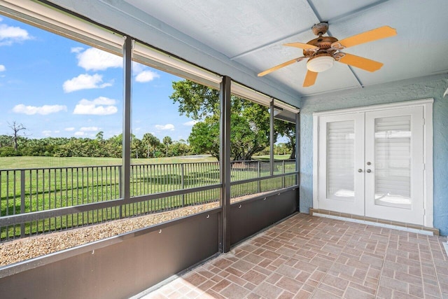 unfurnished sunroom with ceiling fan