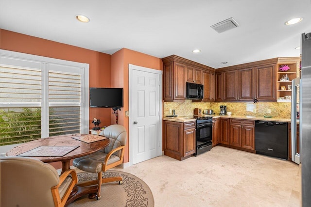 kitchen with light stone counters, backsplash, and black appliances