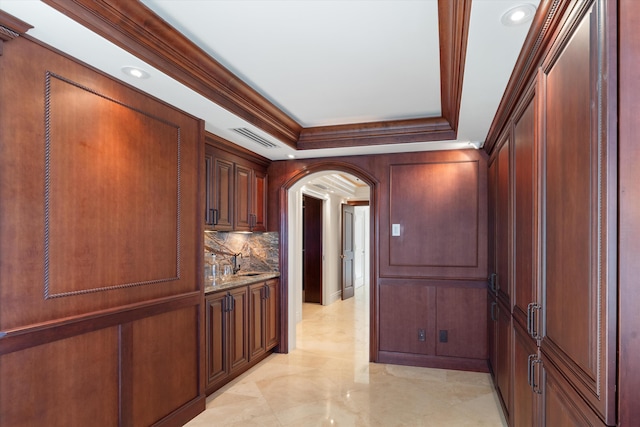 hallway featuring ornamental molding, a tray ceiling, and sink