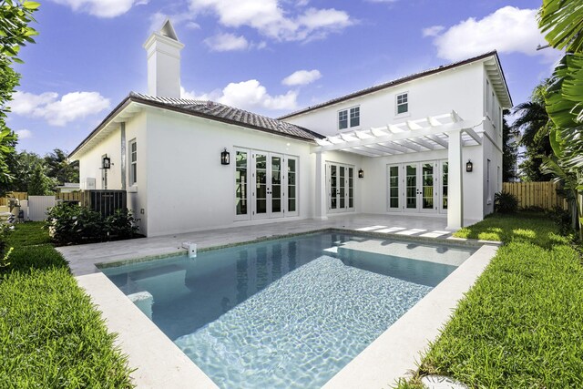 rear view of property with fence, french doors, stucco siding, a pergola, and a patio area