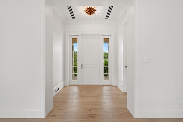 entryway featuring light wood-style flooring, visible vents, ornamental molding, and baseboards