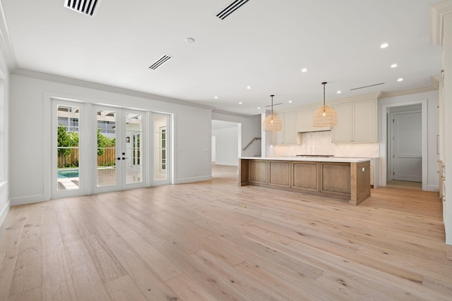 kitchen with ornamental molding, light wood-type flooring, french doors, and visible vents