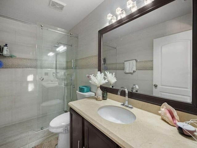 bathroom featuring vanity, walk in shower, and toilet