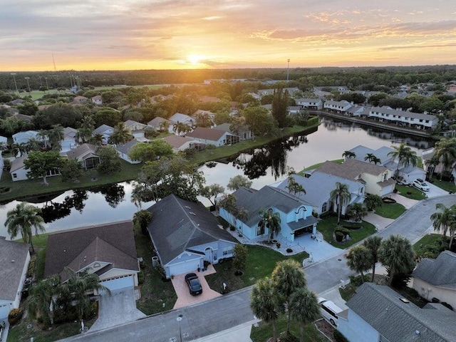 aerial view at dusk featuring a water view