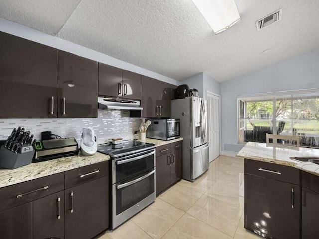 kitchen with tasteful backsplash, appliances with stainless steel finishes, dark brown cabinets, and lofted ceiling