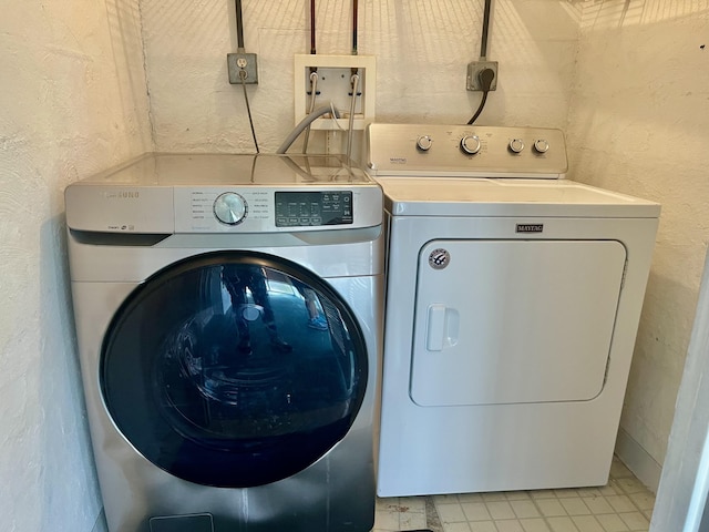 15 Lake Vista Trl Unit 206, Port Saint Lucie, FL 34952 - washroom featuring washer and clothes dryer, light tile patterned flooring, and a textured wall