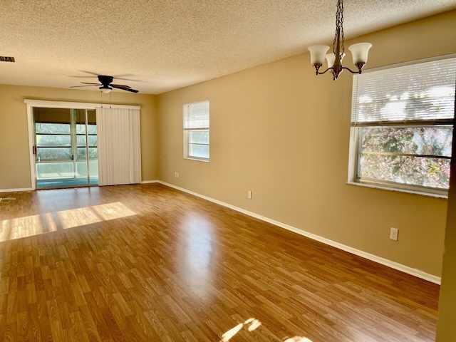 15 Lake Vista Trl Unit 206, Port Saint Lucie, FL 34952 - empty room with a textured ceiling, ceiling fan, wood finished floors, a chandelier, and baseboards