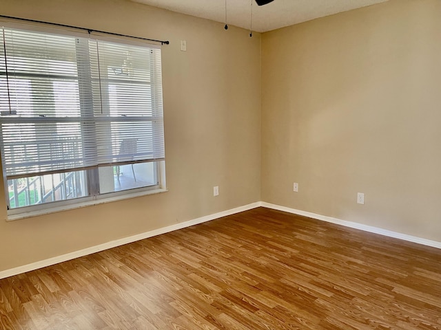 spare room featuring wood-type flooring and ceiling fan