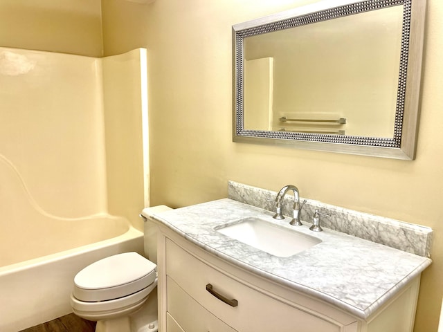 full bathroom featuring vanity, hardwood / wood-style flooring, toilet, and washtub / shower combination