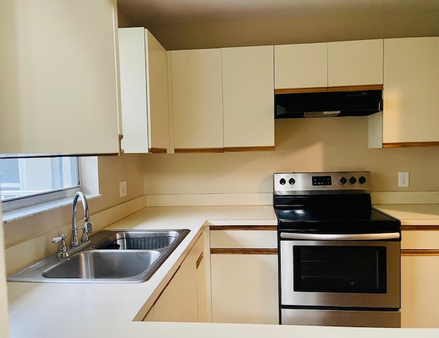 15 Lake Vista Trl Unit 206, Port Saint Lucie, FL 34952 - kitchen featuring under cabinet range hood, electric range, a sink, light countertops, and white cabinets