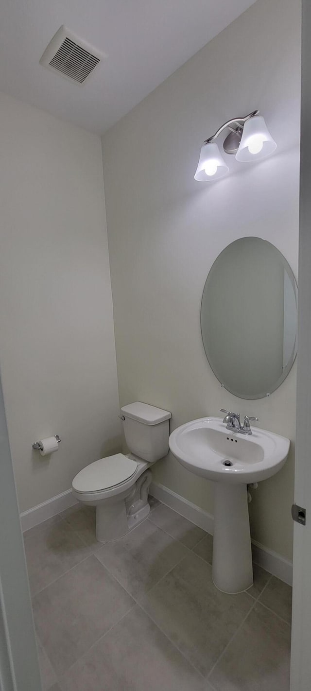 bathroom featuring toilet, tile patterned flooring, visible vents, and baseboards