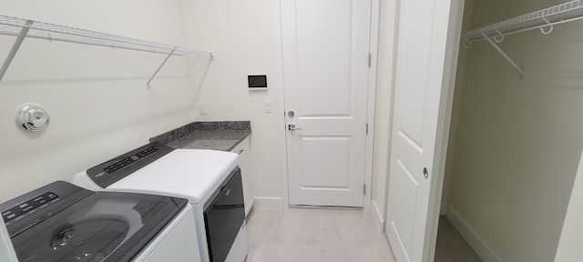 laundry area with washer and dryer, laundry area, baseboards, and light tile patterned floors