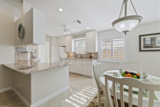 kitchen with white cabinetry, decorative backsplash, hanging light fixtures, kitchen peninsula, and white appliances