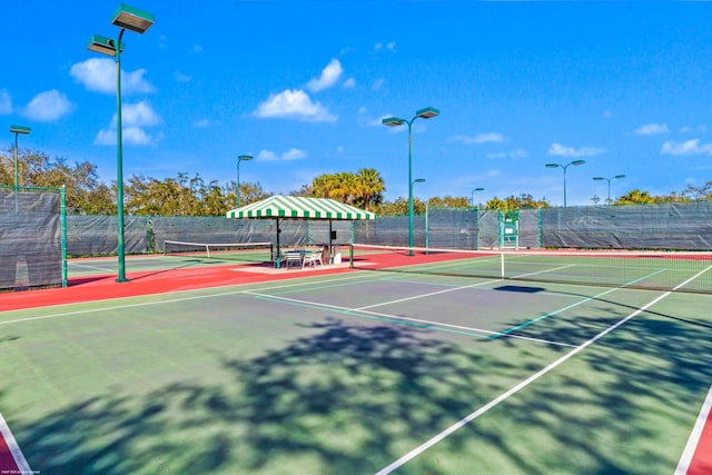 view of tennis court with basketball hoop