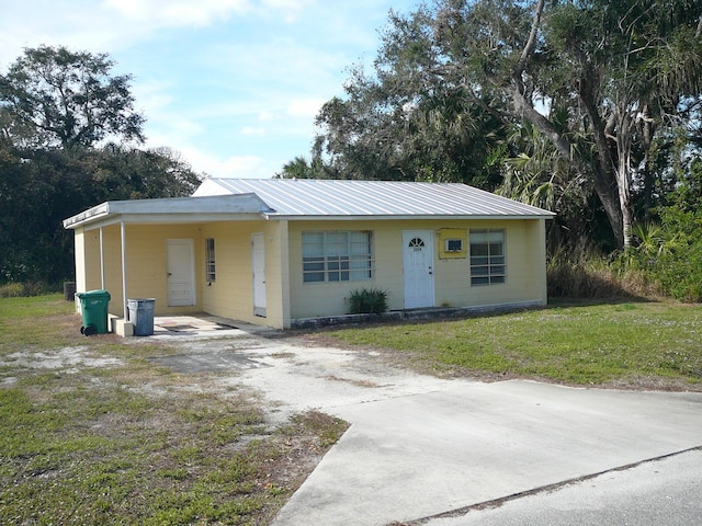 view of front facade with a front yard and a carport