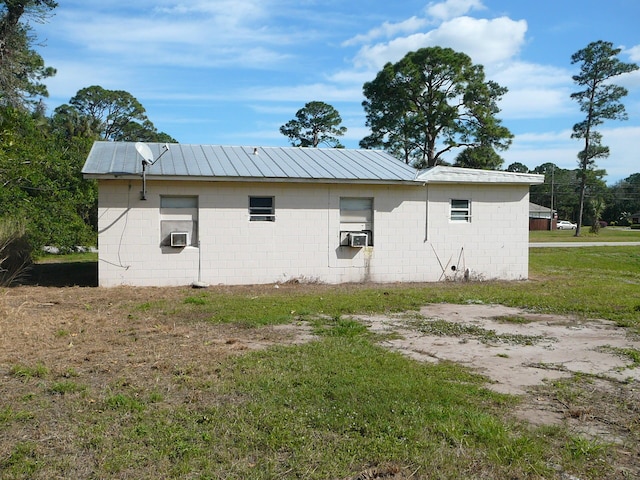 view of side of home featuring cooling unit and a lawn