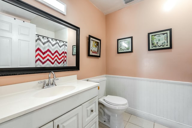 bathroom with a shower with shower curtain, vanity, toilet, and tile patterned flooring