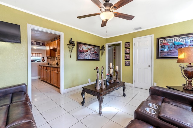 tiled living room featuring crown molding, sink, and ceiling fan