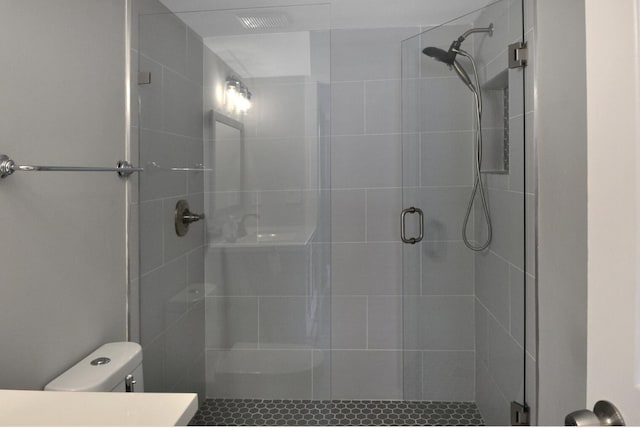 bathroom featuring an enclosed shower and toilet